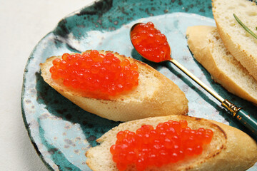 Tasty bruschettas with red caviar on white background