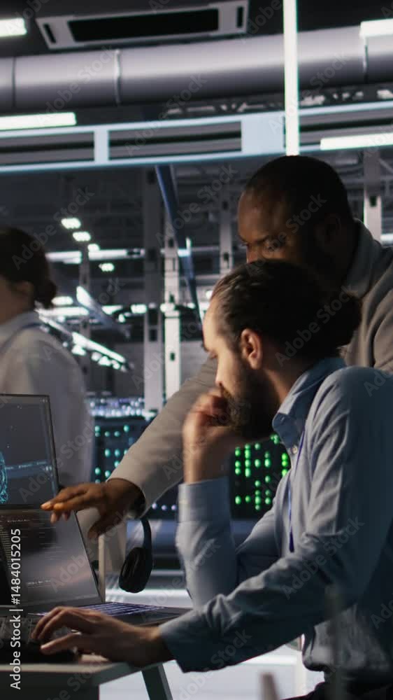 Poster vertical video data center engineers use laptop, collaborating on doing ai software updates. server 
