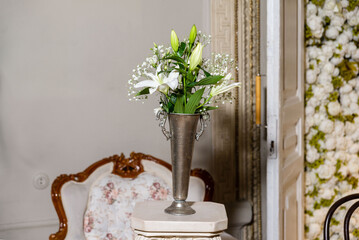 Elegant white lily bouquet in metal vase.