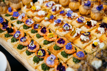 Gourmet shrimp and bruschetta canapés with flowers.