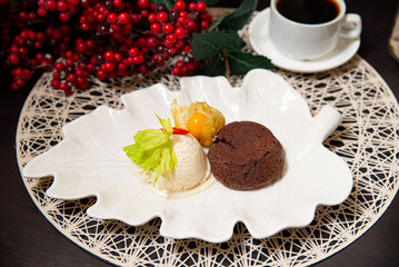 Chocolate lava cake with ice cream and coffee. Elegant dessert featuring molten chocolate lava cake with vanilla ice cream, garnished with physalis, served with black coffee.