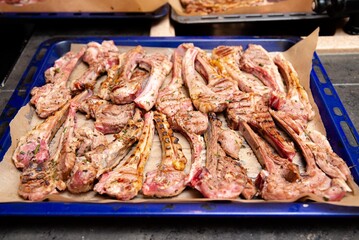 Grilled Lamb Chops on Baking Tray with Herbs. Freshly grilled lamb chops seasoned with herbs, arranged on a parchment-lined baking tray, ideal for gourmet meat dishes.