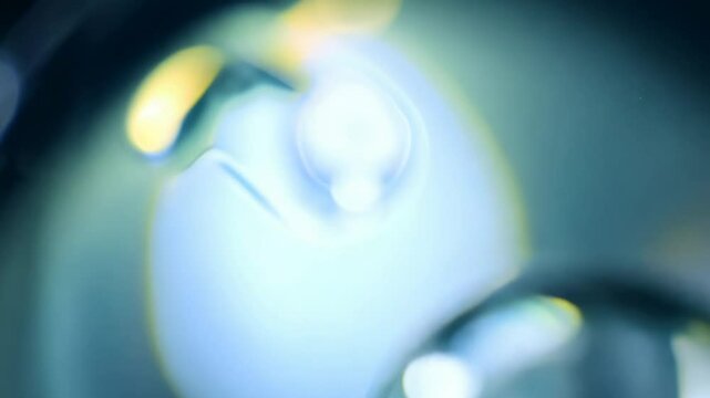 Single drop of water captured with macro lens and single focused light source as it splashes, revealing intricate patterns and light refractions. Concept of microcosmic beauty and complexity