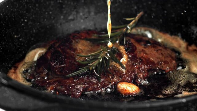 Beef steak in a pan with garlic and spices. Filmed on a high-speed camera at 1000 fps. High quality FullHD footage