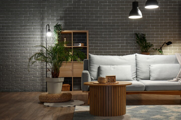 Stylish interior of living room with sofa at night