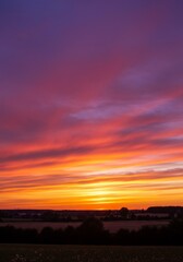 Obraz premium Vibrant Sunset Landscape with Orange and Purple Clouds