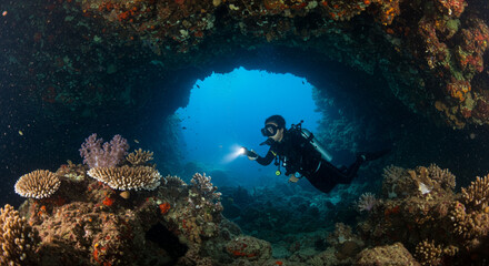 Scuba Diver Exploring Underwater Cave illuminated with Diving Light Reveals Coral Reefs Adventure Deep Sea Exploring the Depths of the Ocean Diving Expedition
