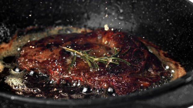 Beef steak in a pan with garlic and spices. Filmed on a high-speed camera at 1000 fps. High quality FullHD footage