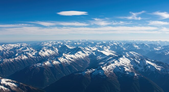 Snowy mountain range under blue sky representing natural beauty and serene landscape, with aerial perspective - Powered by Adobe