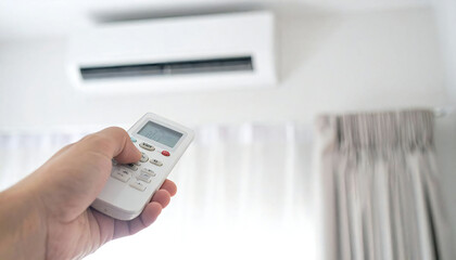 エアコンのリモコンを持つ手。快適な部屋の背景イメージ。Hand holding air conditioner remote control. Comfortable room background image.