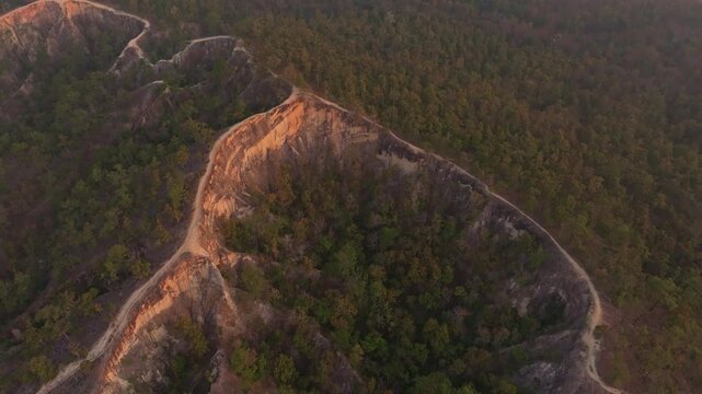 Soft golden glow warms canyon edges in northern Pai, Thailand Aerial drone video