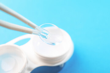 Taking contact lens from case on light background, closeup. Space for text