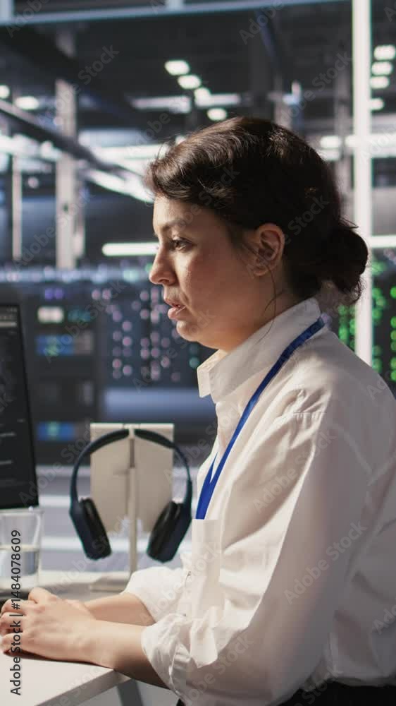 Poster vertical video tired data center engineer stretching, monitoring server clusters performing ai train