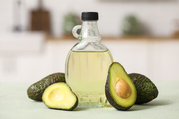 Bottle of fresh avocado oil on green table in kitchen