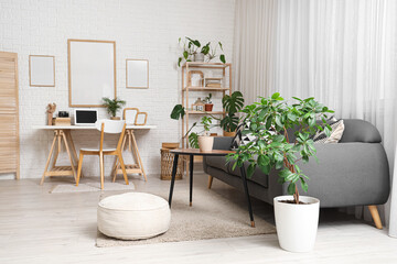 Blank posters and workplace with laptop in living room