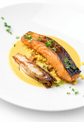 Grilled salmon fillet steak with yellow lentils sauce and roasted vegetables in the plate isolated on white background. Healthy seafood, top view