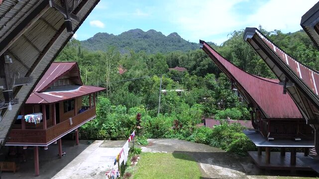 Panoramic Drone View of Tongkonan Houses Amidst Misty Hills of Tana Toraja