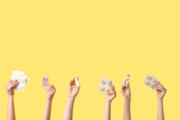Female hands with mustard plasters, nasal spray, thermometer and pill box on yellow background