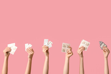 Female hands with mustard plasters and pills on pink background