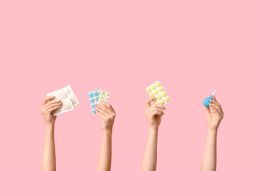 Female hands with mustard plasters, enema and pills on pink background