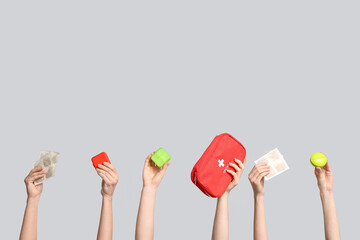 Female hands with mustard plasters, pill boxes and first aid kit on grey background