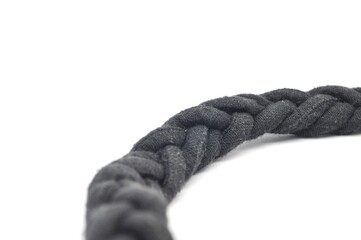 Braided black ropes on light white background, closeup. Unity concept