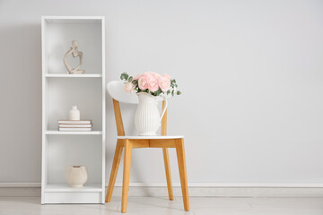 Vase with bouquet of beautiful ranunculus flowers on chair in living room