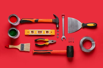 Paint and construction tools on red background