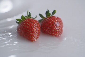 Fresh strawberries resting in creamy milk on a smooth surface, evoking a sense of indulgence