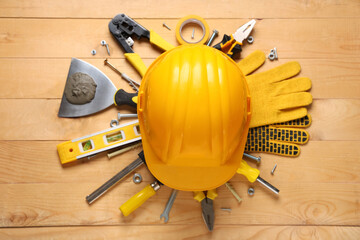 Hardhat and construction tools on wooden background