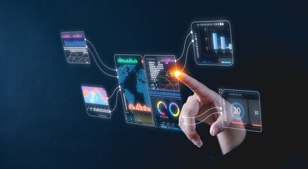 A hand interacts with futuristic virtual data screens displaying analytics and charts on a dark...