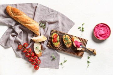 Composition with tasty sandwiches, hummus and fresh sprouts on light background