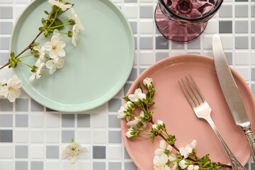 Beautiful table setting with blooming branches on grey tile background