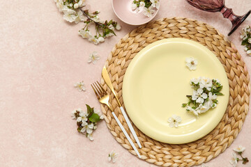 Beautiful table setting with blooming flowers on light pink background
