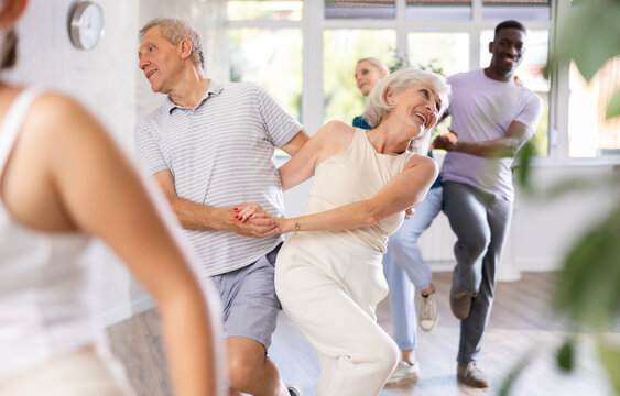 Senior europian man is enjoying his hobby of dancing salsa with his elderly partner at fitness class, relishing in movement and activity. It great way for them to stay active and have fun together.