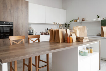 Paper bags with juice on table in kitchen. Food delivery service
