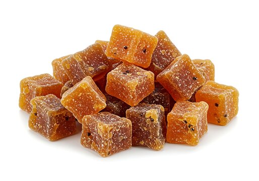A pile of candied ginger cubes on a white background