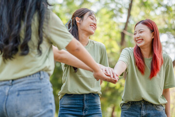 Obraz premium Group of Happy Asian female volunteers team in park for charity event with joining hands