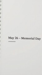Memorial day written on a page of a white notebook with the date displayed