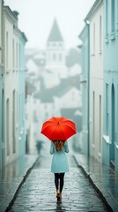 Woman with red umbrella walks down rain-slicked street between buildings