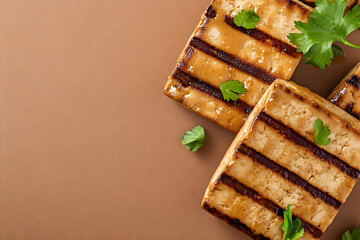 Grilled tofu squares with parsley garnish.
