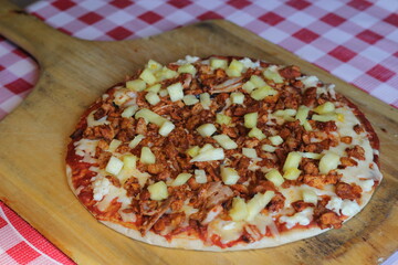 A tempting pizza featuring a blend of pulled al pastor meat and pineapple, highlighting the unique combination of flavors that promises to delight food enthusiasts.
