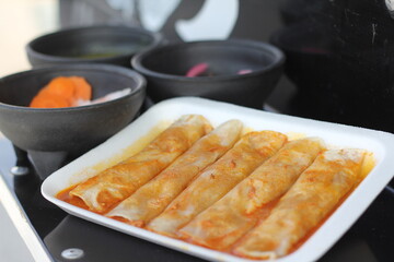 A plate of enchiladas generously coated in savory sauce, served with authentic sides, capturing the essence of traditional Mexican cuisine and home-style cooking.
