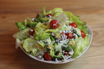 A refreshing green salad featuring crisp lettuce, vibrant cherry tomatoes, and creamy avocado, ideal for promoting healthy eating and fresh ingredients.