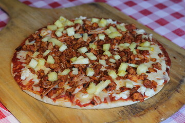 A creative pizza featuring tender al pastor meat and sweet pineapple, combining savory and sweet flavors for a delightful dining experience with friends or family.