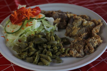 A traditional milanesa plate featuring a variety of fried items and a fresh side salad, representing the comfort and satisfaction of a hearty, home-cooked meal.