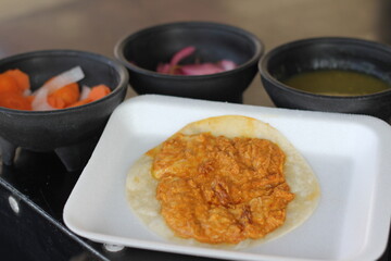 An authentic Mexican dish displayed with rich sauces, served with a warm tortilla, highlighting the vibrant flavors and cultural essence of Mexican gastronomy.