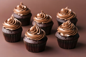 Chocolate cupcakes with rich, swirled frosting, displayed on a dark background.