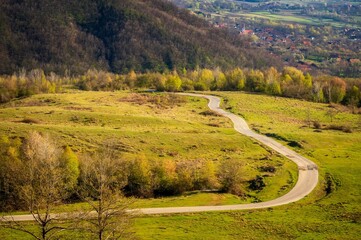 Winding country road in the mountains with a village in the valley.