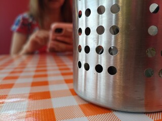 WOMAN IN A RESTAURANT LOOKING AT HER CELL PHONE IN A FLAT SEDUNDUM,


